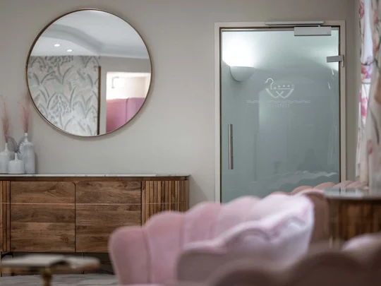 ENTspannen Moderner Innenraum mit rundem Spiegel, Holzkommode und Glasduschtür