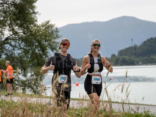 Zwei Läufer geben während eines Rennens am See Daumen hoch