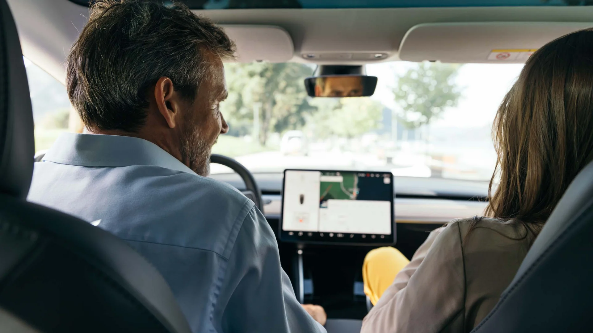 Von eurem Zuhause zu uns in den Wiesenhof Mann und Frau sitzen im Auto und schauen auf das Navigationssystem