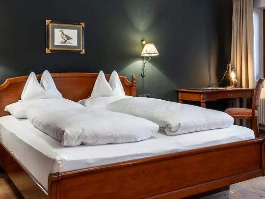 Zimmer und Suiten im Wiesenhof Gemütliches Doppelzimmer mit Holzbett und Schreibtisch neben Fenster