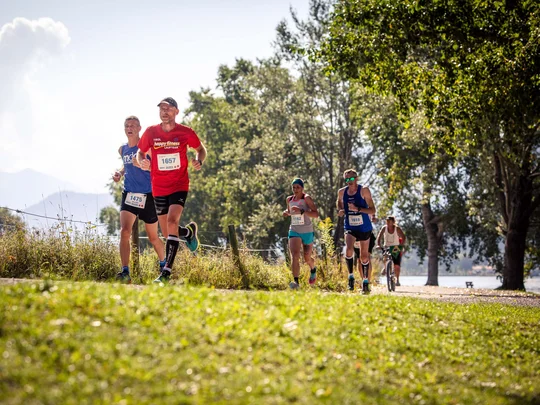 Läufer und Radfahrer auf einem Weg im Park bei sonnigem Wetter