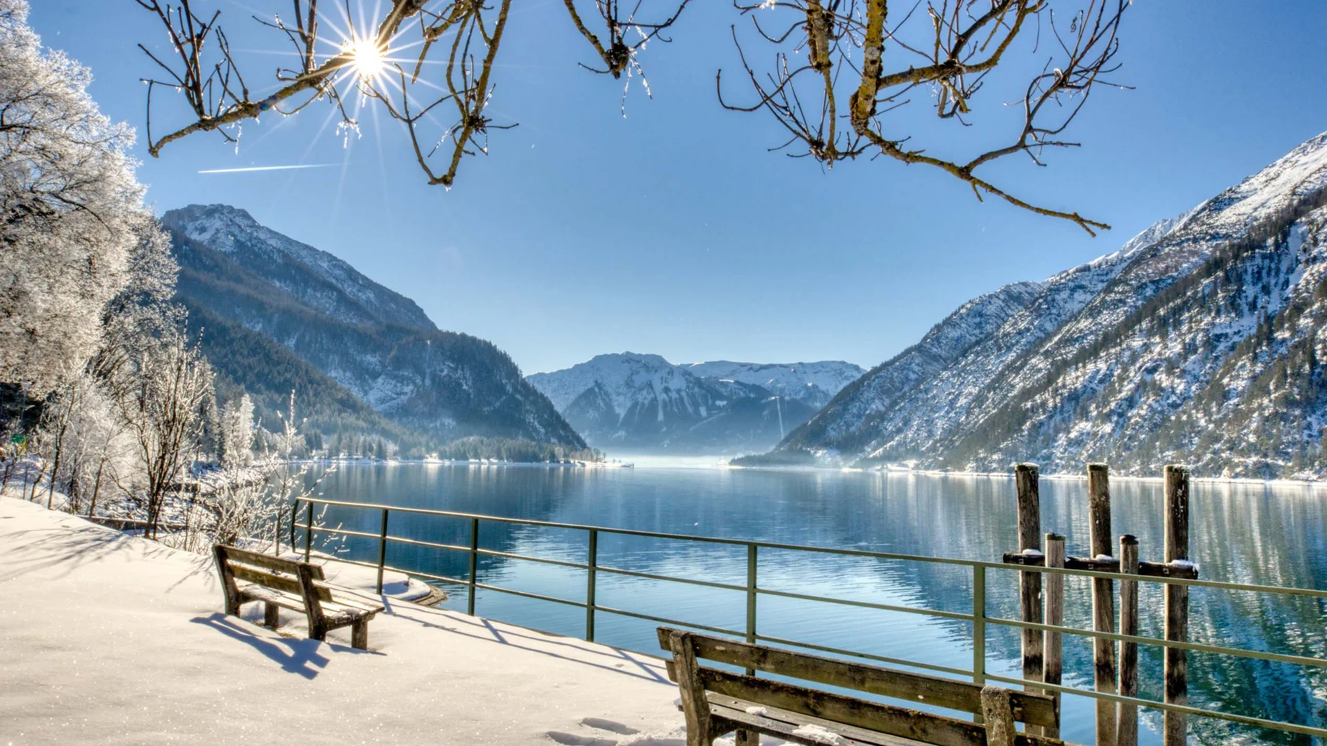 Winterlandschaft mit schneebedeckten Bergen und See bei Sonnenschein