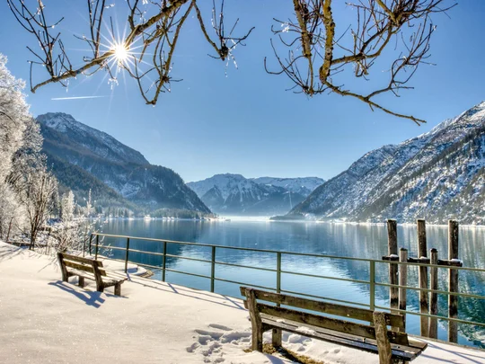 In, auf und rund um den Achensee Winterlandschaft mit schneebedeckten Bergen und See bei Sonnenschein