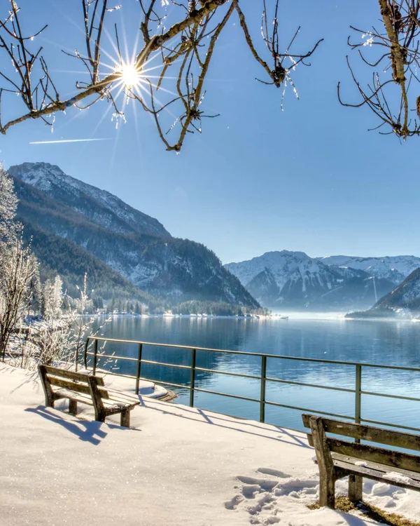 Winterlandschaft mit schneebedeckten Bergen und See bei Sonnenschein