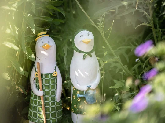 Der Wiesenhof in Pertisau und die Familie Entner mit Team Zwei Gänse-Figuren mit Gartengeräten zwischen grünen Pflanzen