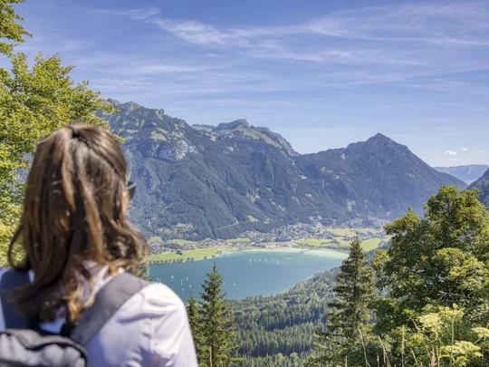In, auf und rund um den Achensee Frau mit Rucksack blickt auf Bergsee und Alpenlandschaft bei klarem Himmel