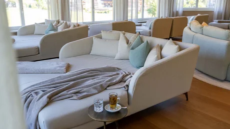 Moderner gemütlicher Lounge-Bereich mit Sofas, Kissen und Getränken am Fenster