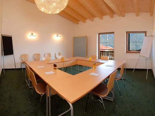 Seminarräume Achensee | Tagungshotel Wiesenhof Tirol Klare Konferenzraum mit U-förmigem Tisch, Stühlen und Flipcharts