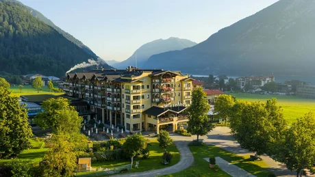 Hotel Wiesenhof im Tal mit Bergen im Hintergrund und sonnigem Wetter