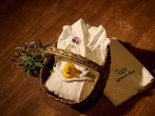 Eure Fragen – unsere Wiesenhof Antworten Wellnesskorb mit Bademantel, Quietscheentchen und Lavendel auf Holzboden