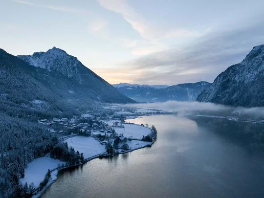 In, auf und rund um den Achensee Verschneites Tal mit Bergen und ruhigem See bei Dämmerung