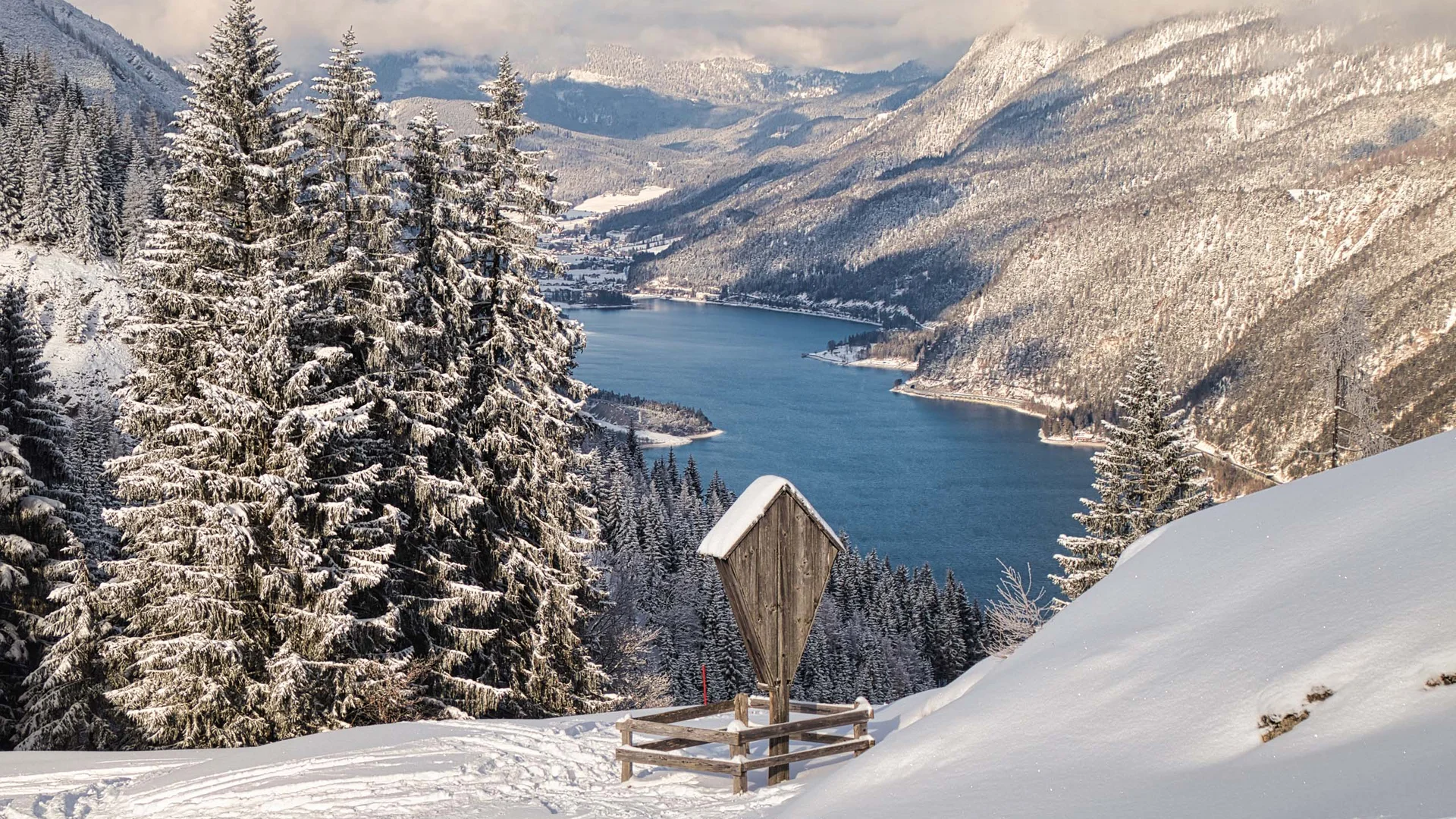 In, auf und rund um den Achensee Schneebedeckte Bäume und ein See in einem verschneiten Bergtal