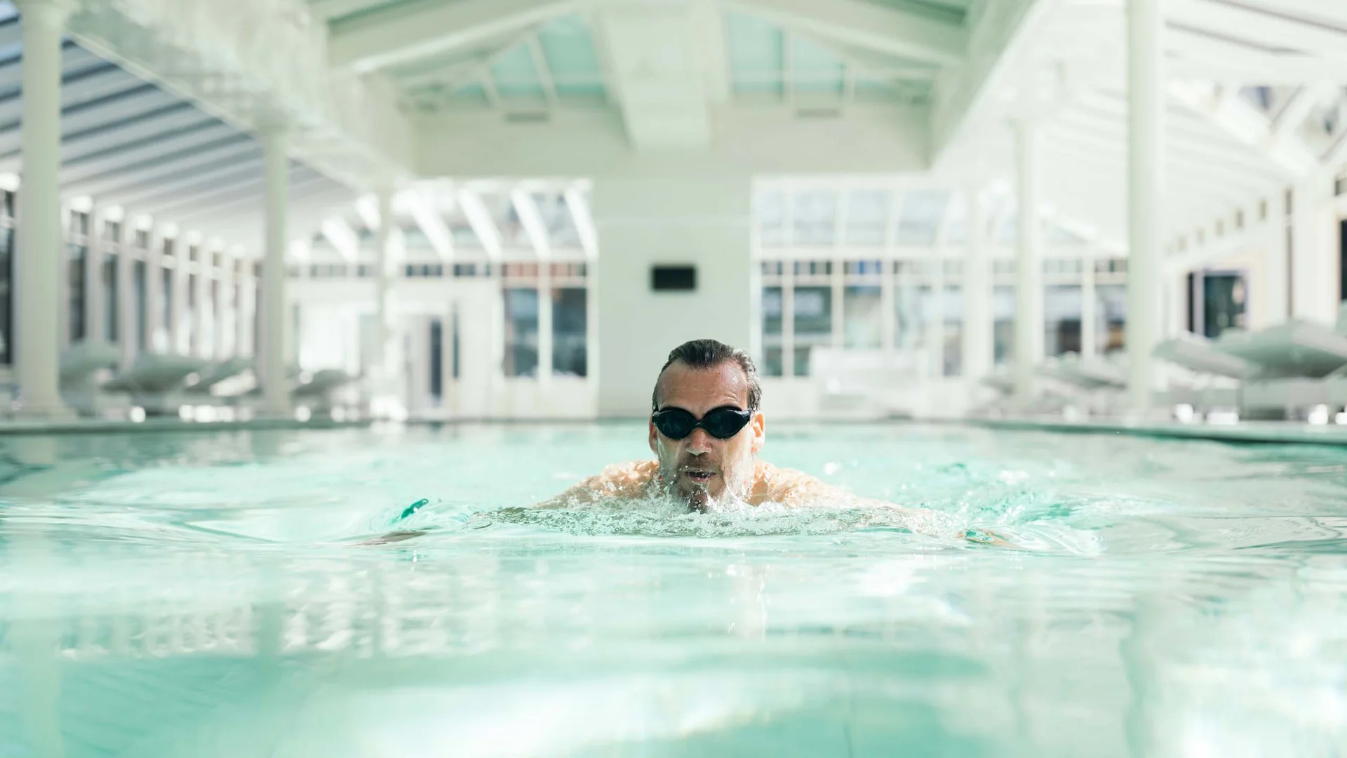 Ganz im Zeichen des Trainings: dieses Sporthotel am Achensee Mann schwimmt mit Schwimmbrille in einem Hallenbad