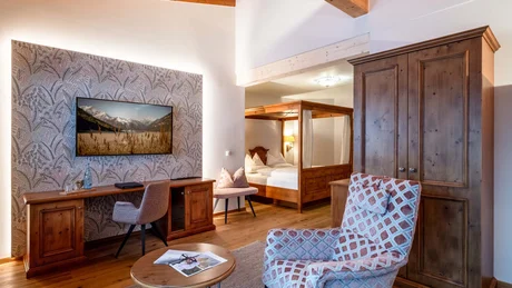 Gemütliches Hotelzimmer mit Holzmöbeln und Fernseher an der Wand