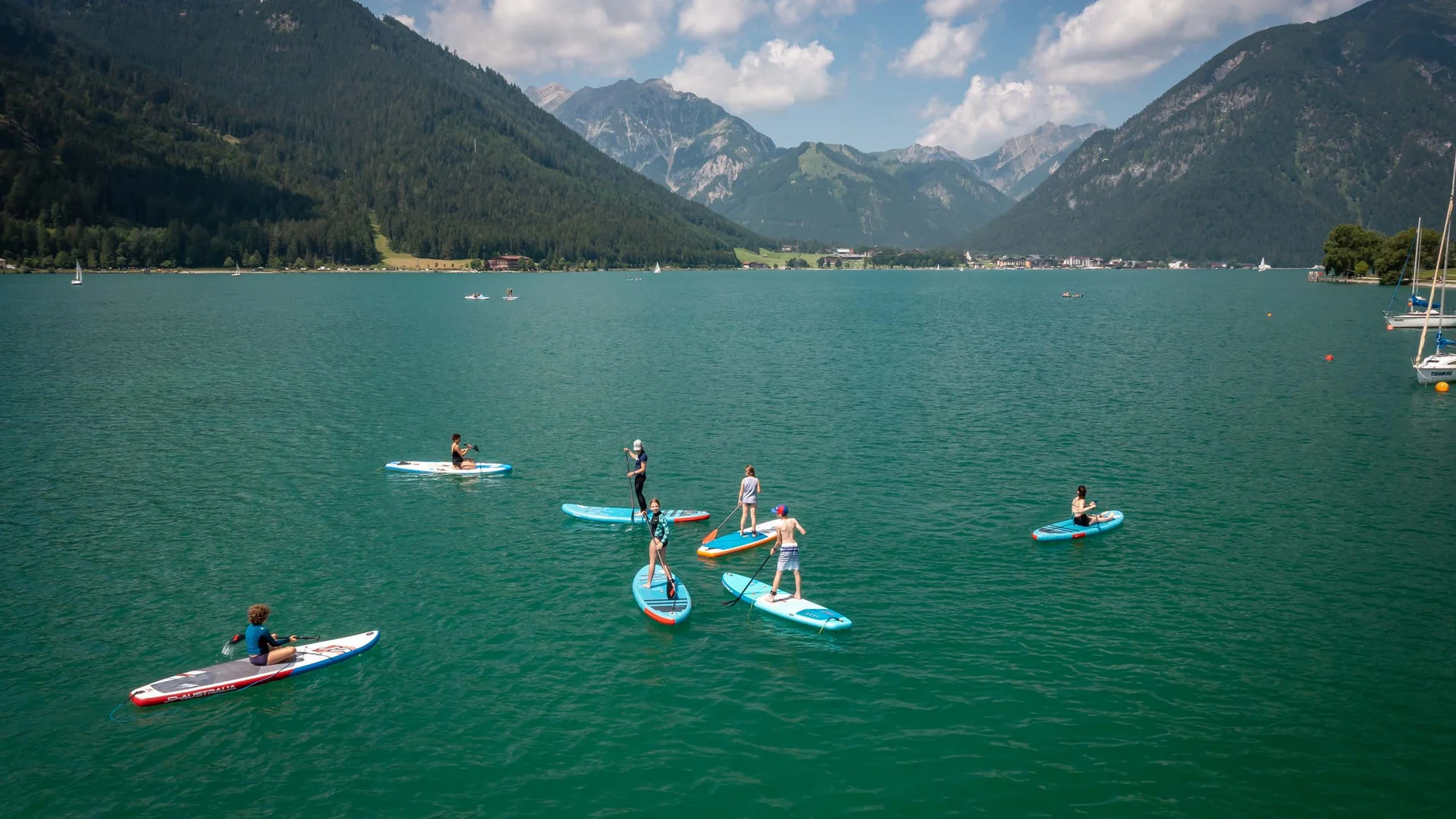 Sehenswürdigkeiten am Achensee rund um den Wiesenhof Menschen paddeln auf Stand-Up-Paddleboards auf einem See in den Bergen