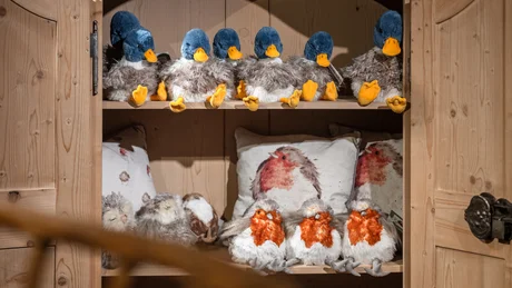 Holzschrank mit Kuscheltieren und Kissen mit Tiermotiven