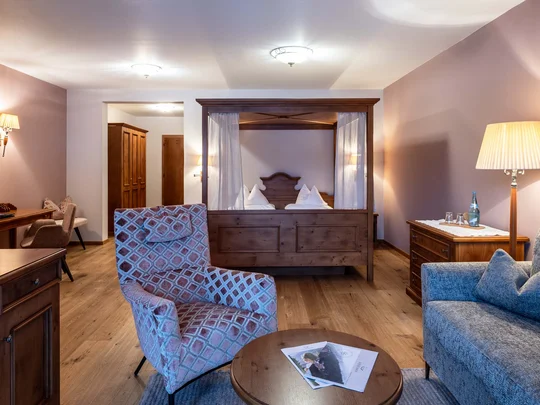 Zimmer und Suiten im Wiesenhof Gemütliches Hotelzimmer mit Himmelbett, Sesseln und Holzmöbeln