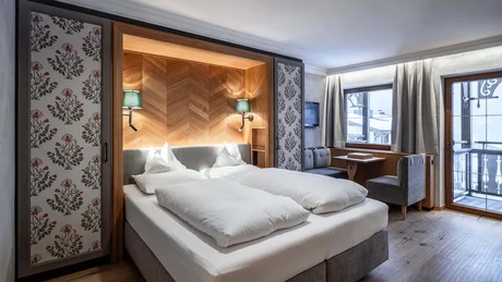 Gemütliches Hotelzimmer mit Doppelbett, Sitzecke und Balkon mit Bergblick