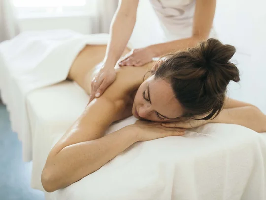 Das 4-Sterne-Hotel am Achensee: der Wiesenhof Frau erhält entspannende Rückenmassage auf Massagetisch