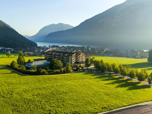 Familienhotel mit Ponyreiten am Achensee | Wiesenhof Pertisau Grünes Tal mit Hotels, Bergen und See im Morgendunst