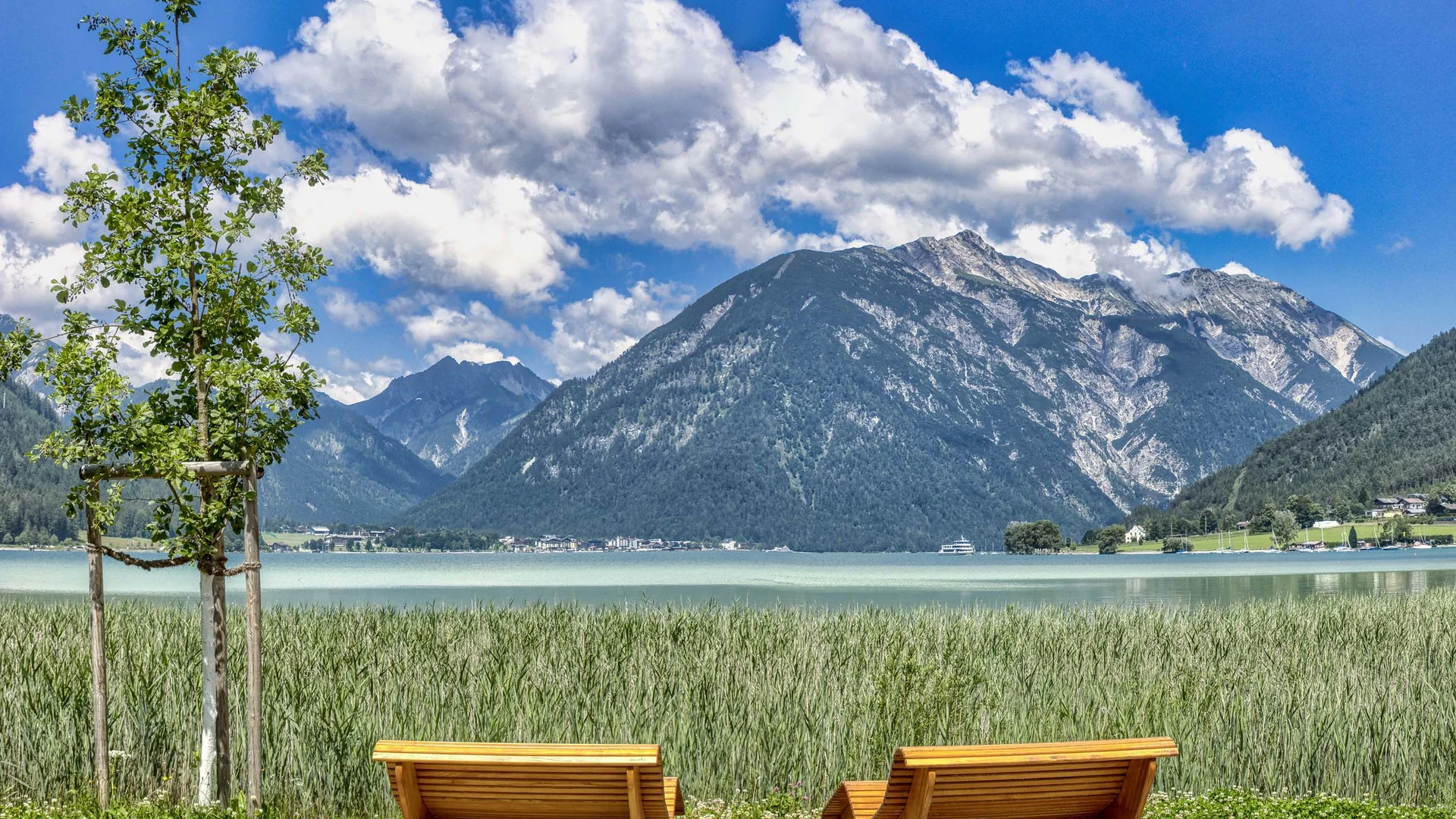 In, auf und rund um den Achensee Zwei Holzbänke mit Blick auf See, Berge und blauen Himmel mit Wolken
