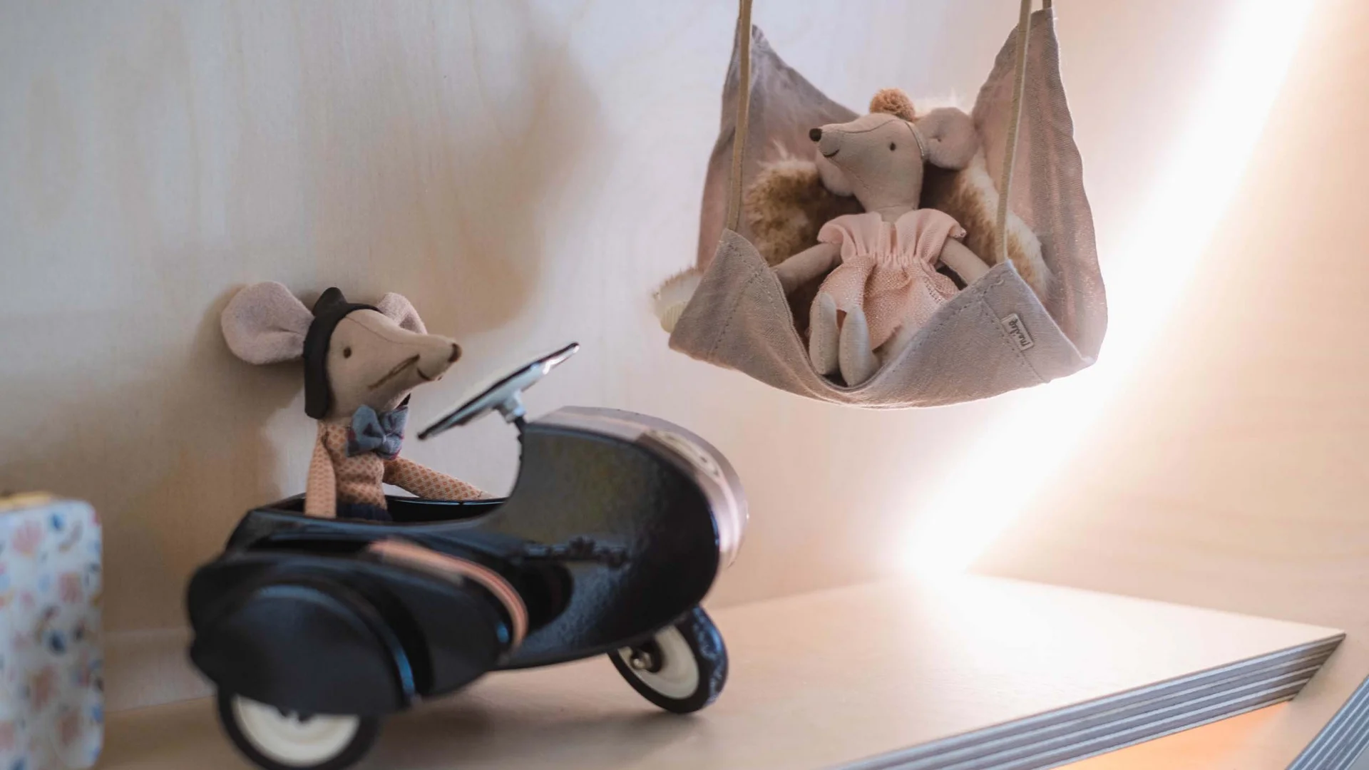 Euer Familienhotel am Achensee Zwei Mauspuppen, eine in einem Spielzeugauto, eine in einer hängenden Stoffschaukel