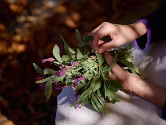 Der Wiesenhof in Pertisau und die Familie Entner mit Team Hände halten einen Strauß grüner Blätter und violetter Blumen