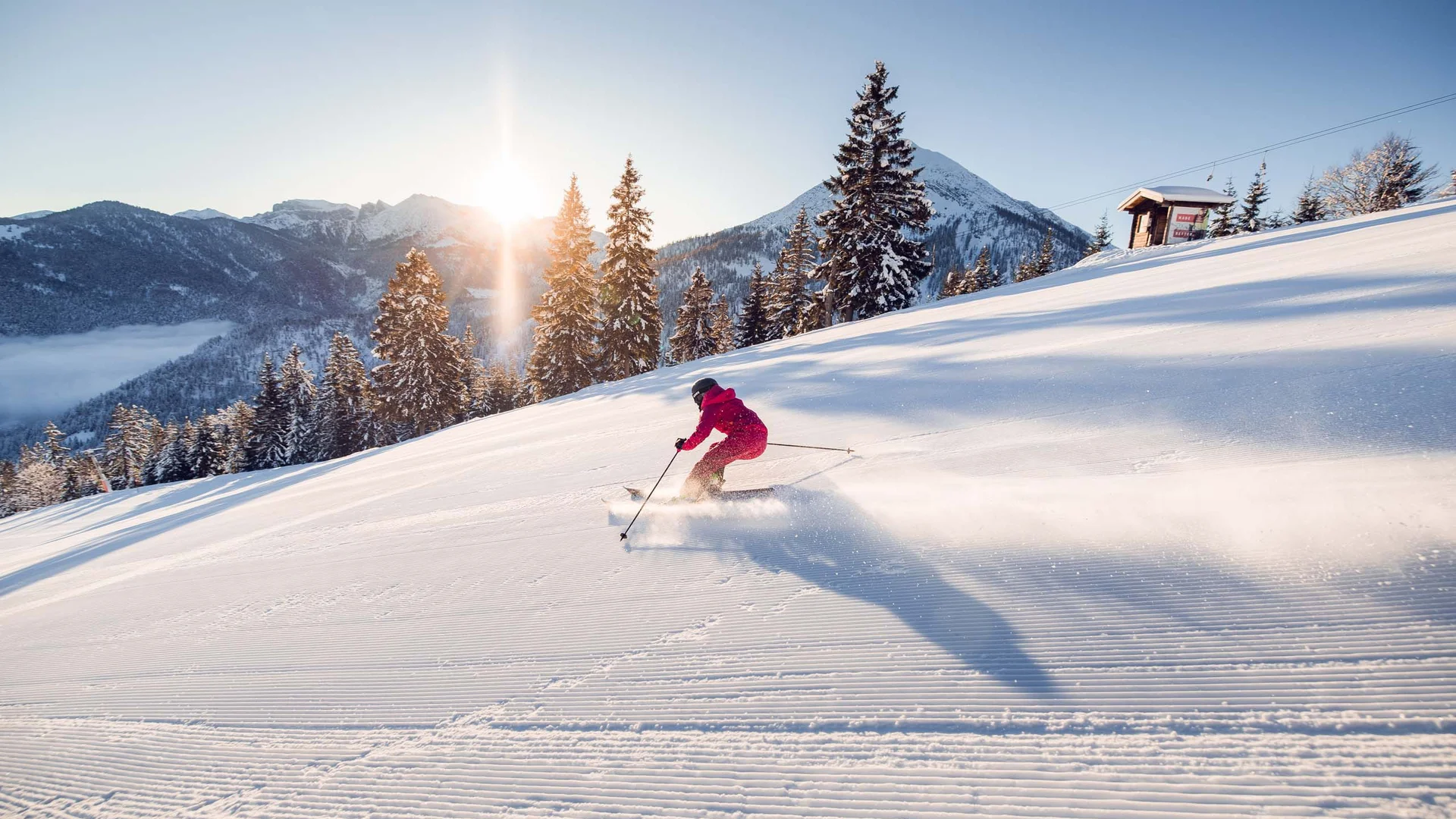Den Achensee entdecken Skifahrer fährt bei Sonnenschein auf frisch präparierter Skipiste