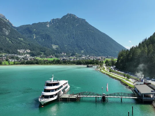 Sehenswürdigkeiten am Achensee rund um den Wiesenhof Bootsanlegestelle am klaren See vor Bergen und Wald im Sommer