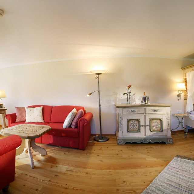 Gemütliches Zimmer mit Bett und Sitzbereich.
