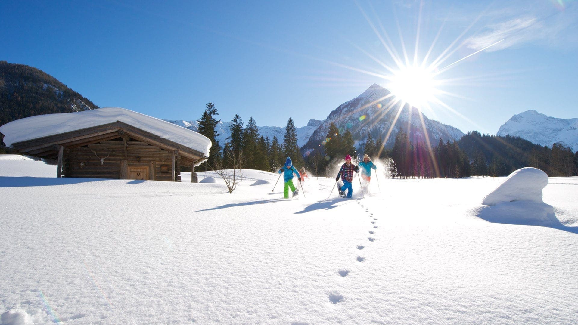 Kinder im Schnee mit Bergen im Hintergrund
