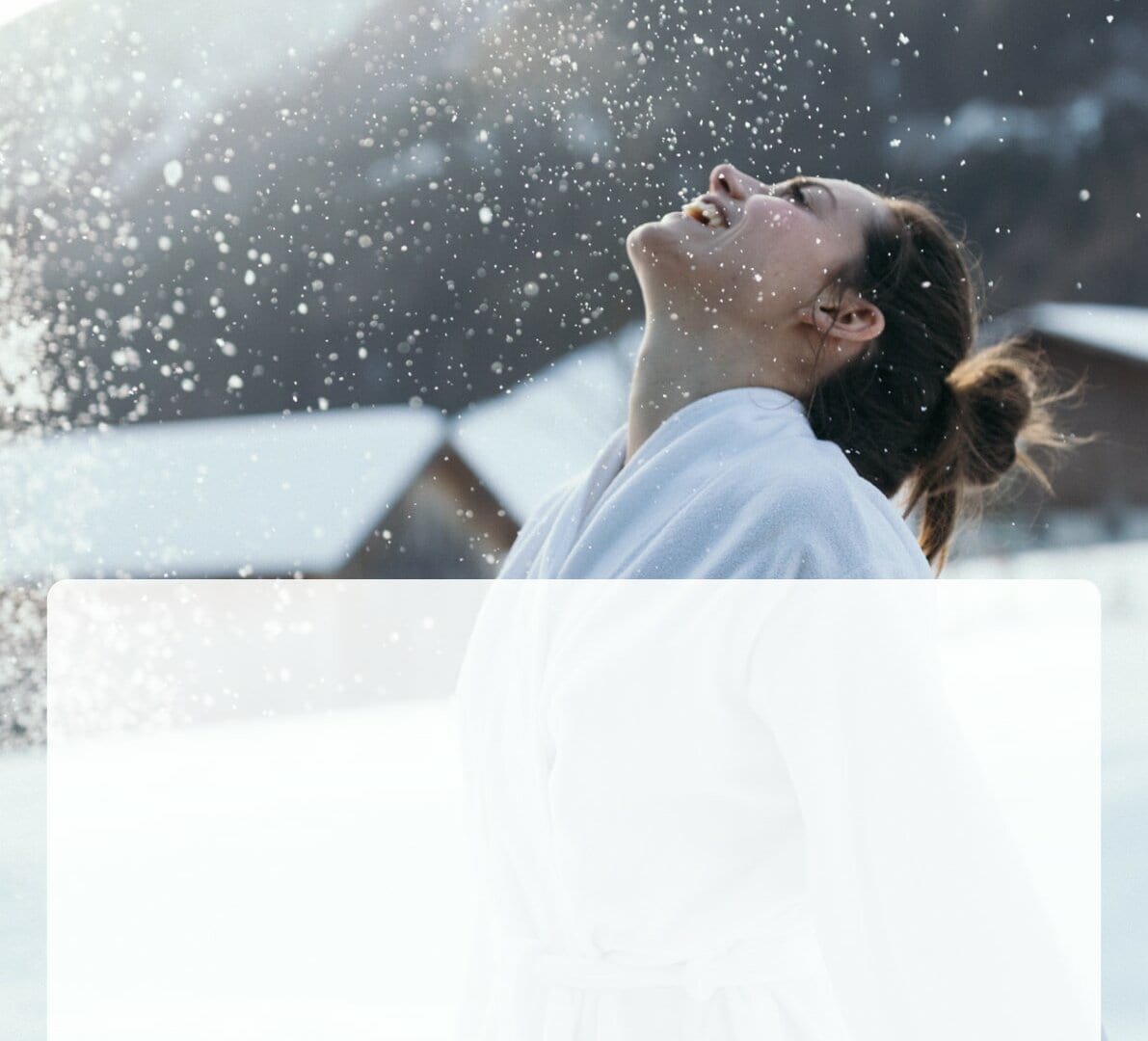 Frau genießt frische Schneeluft im Hotel.