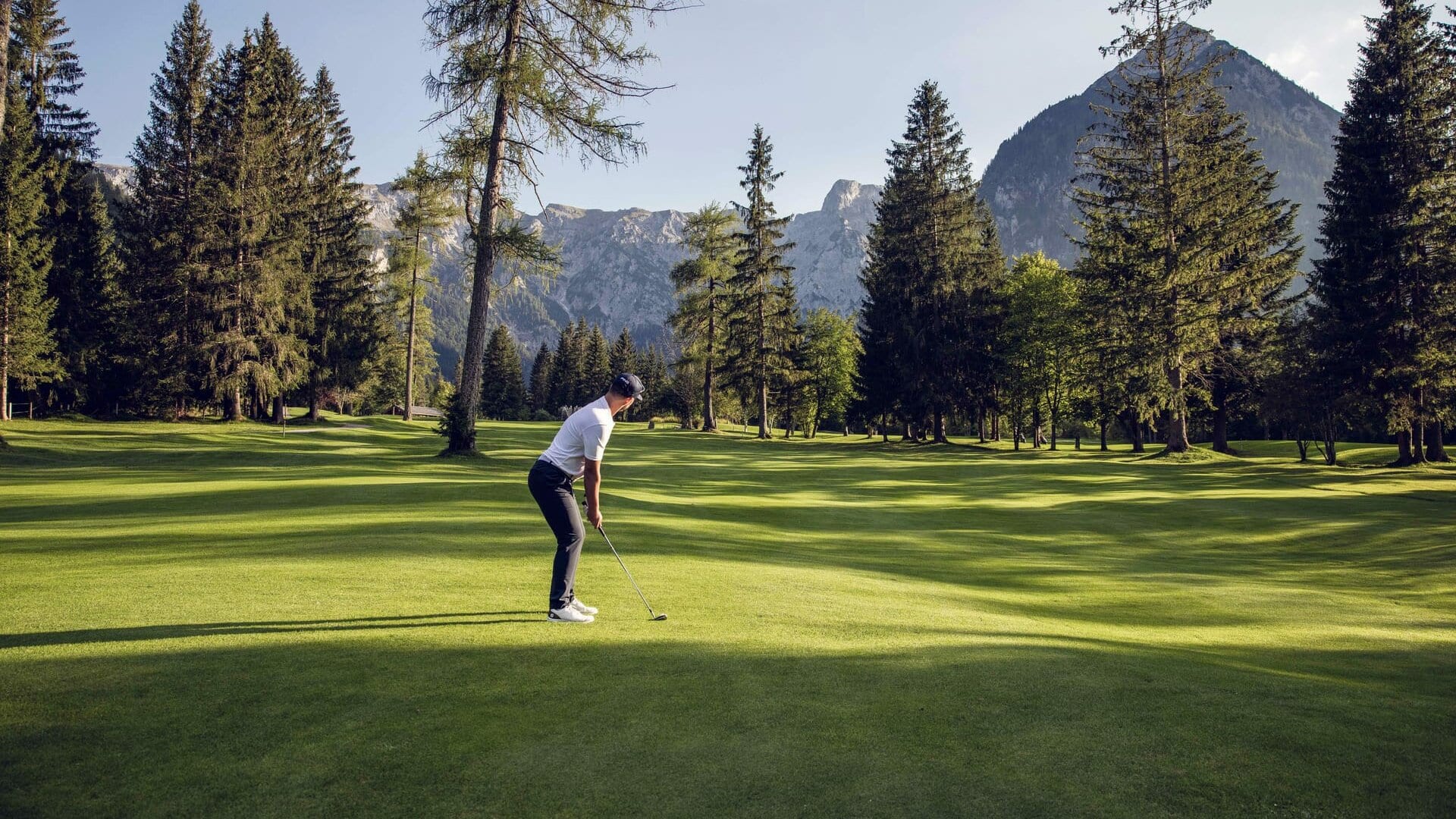 Golfer steht auf einem grünen Golfplatz.