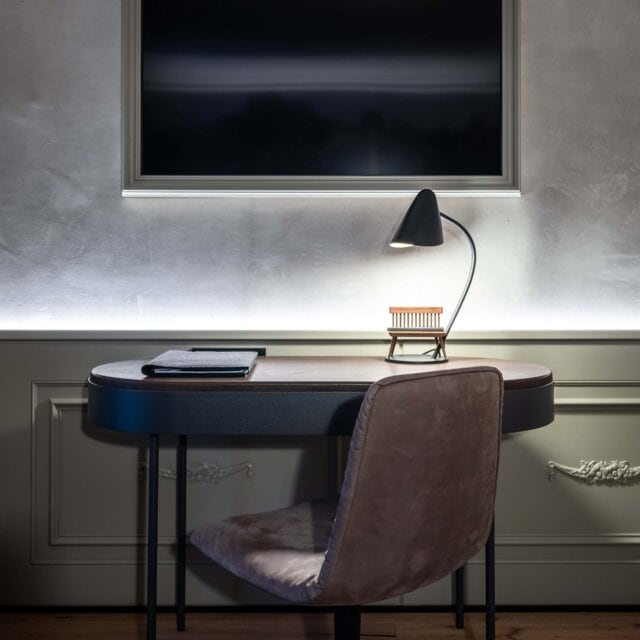 Modernes Arbeitszimmer mit Schreibtisch und Lampe