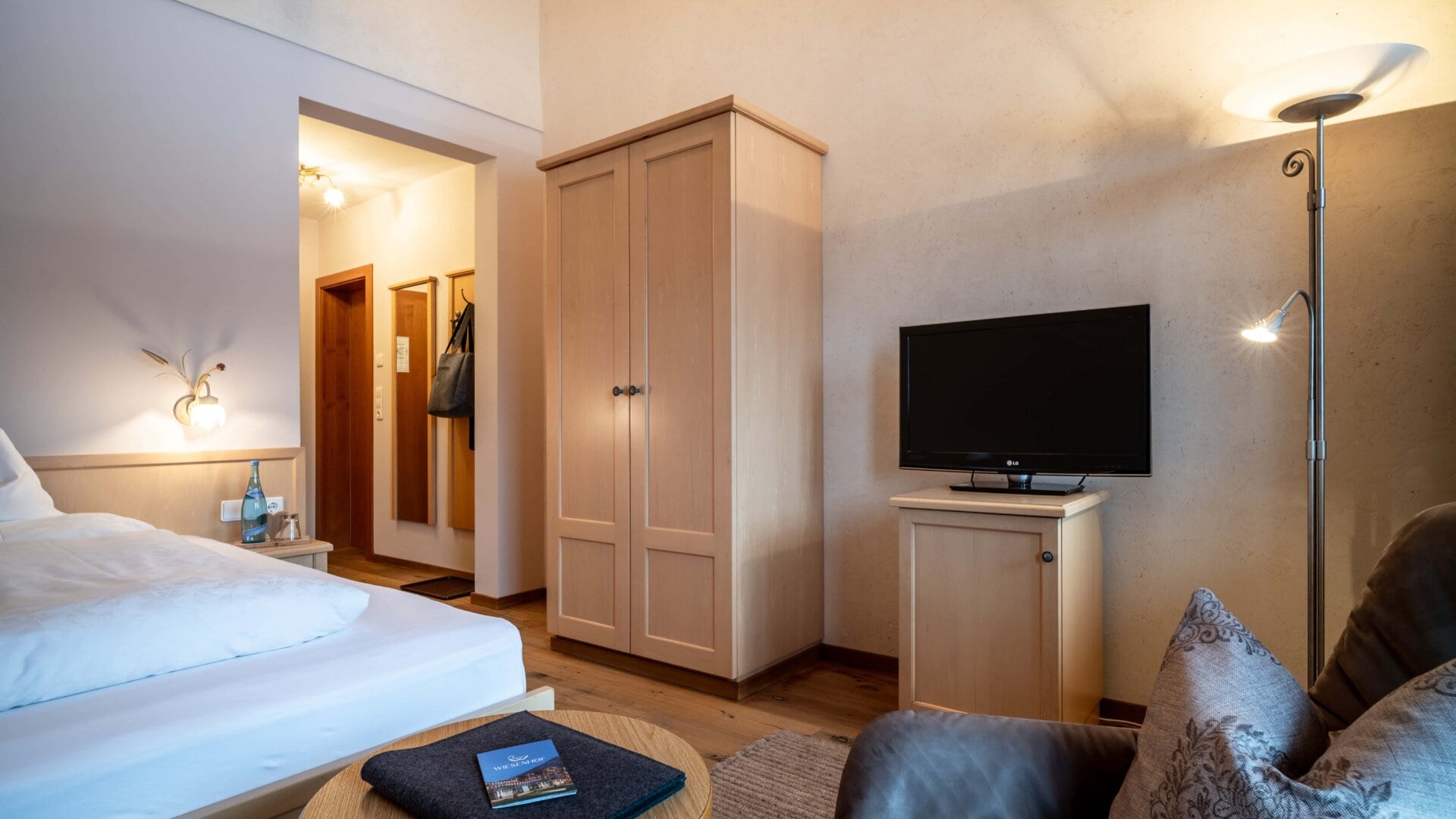 Gemütliches Hotelzimmer mit TV und Möbeln.