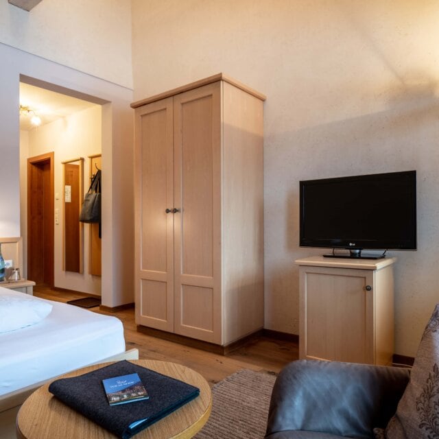 Gemütliches Hotelzimmer mit TV und Möbeln.