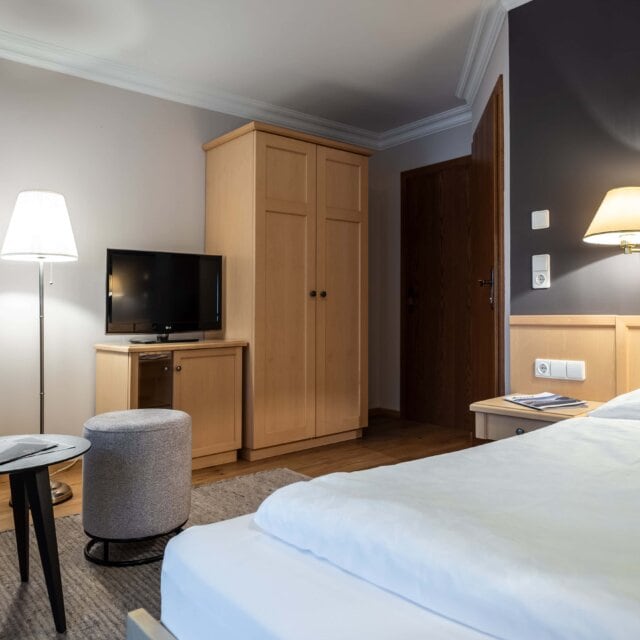 Gemütliches Hotelzimmer mit Fernseher und Lampe.