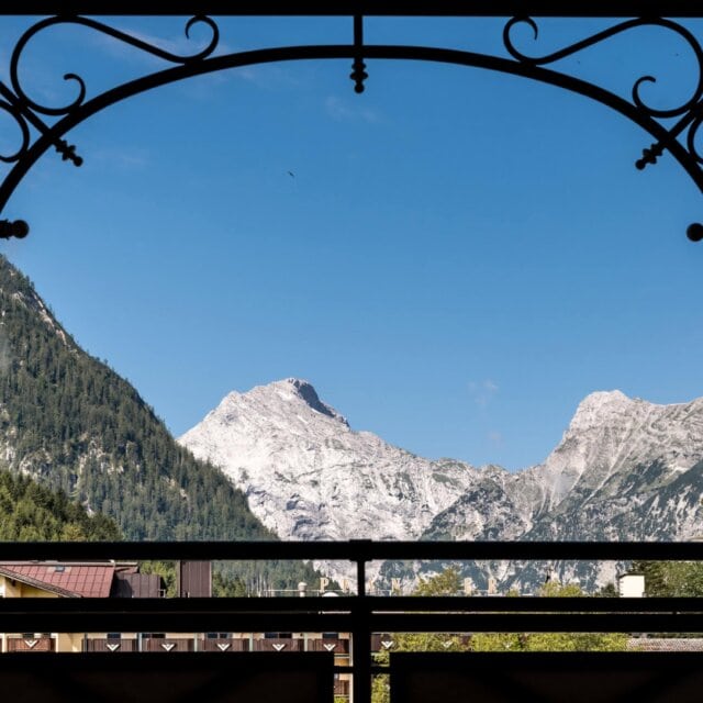 Blick auf Berge durch ein kunstvolles Fenster