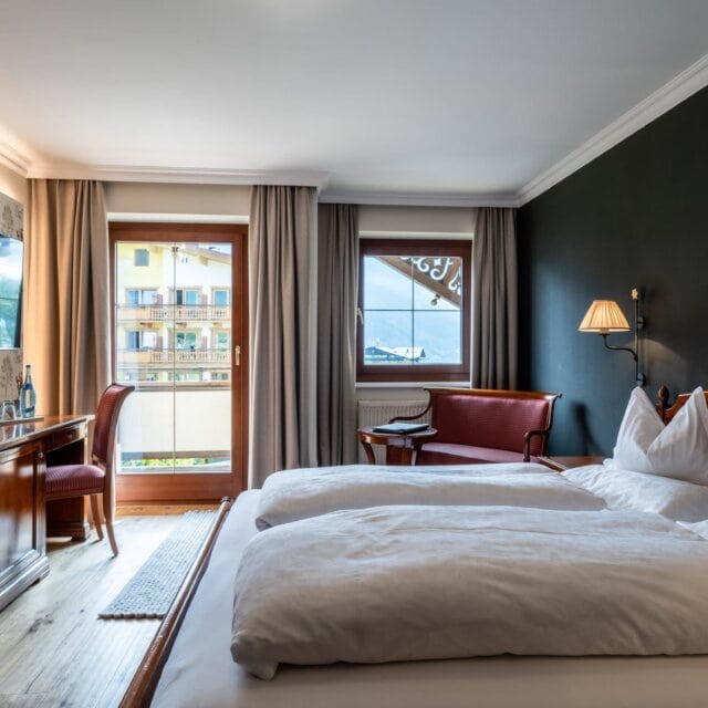 Gemütliches Hotelzimmer mit Fernseher und Balkonblick
