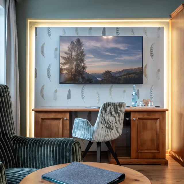 Modernes Wohnzimmer mit Fernseher und gemütlichen Möbeln