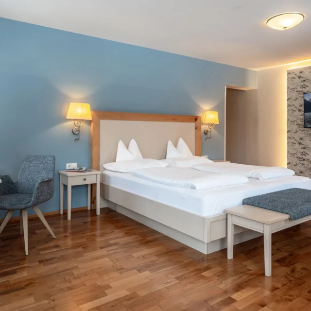Helles Zimmer mit Bett und moderner Einrichtung.